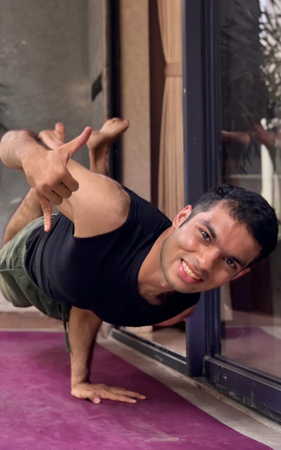 Coach today, smiling while balancing on one hand in a bodyweight yoga pose